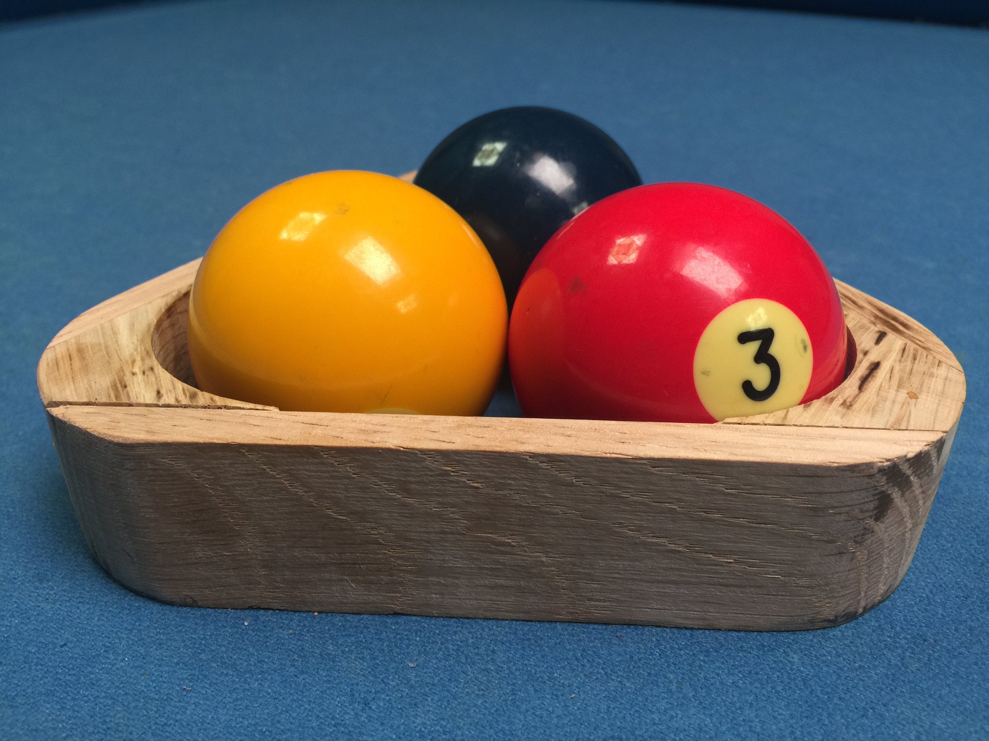 Handmade 3-ball rack with billiard balls on table