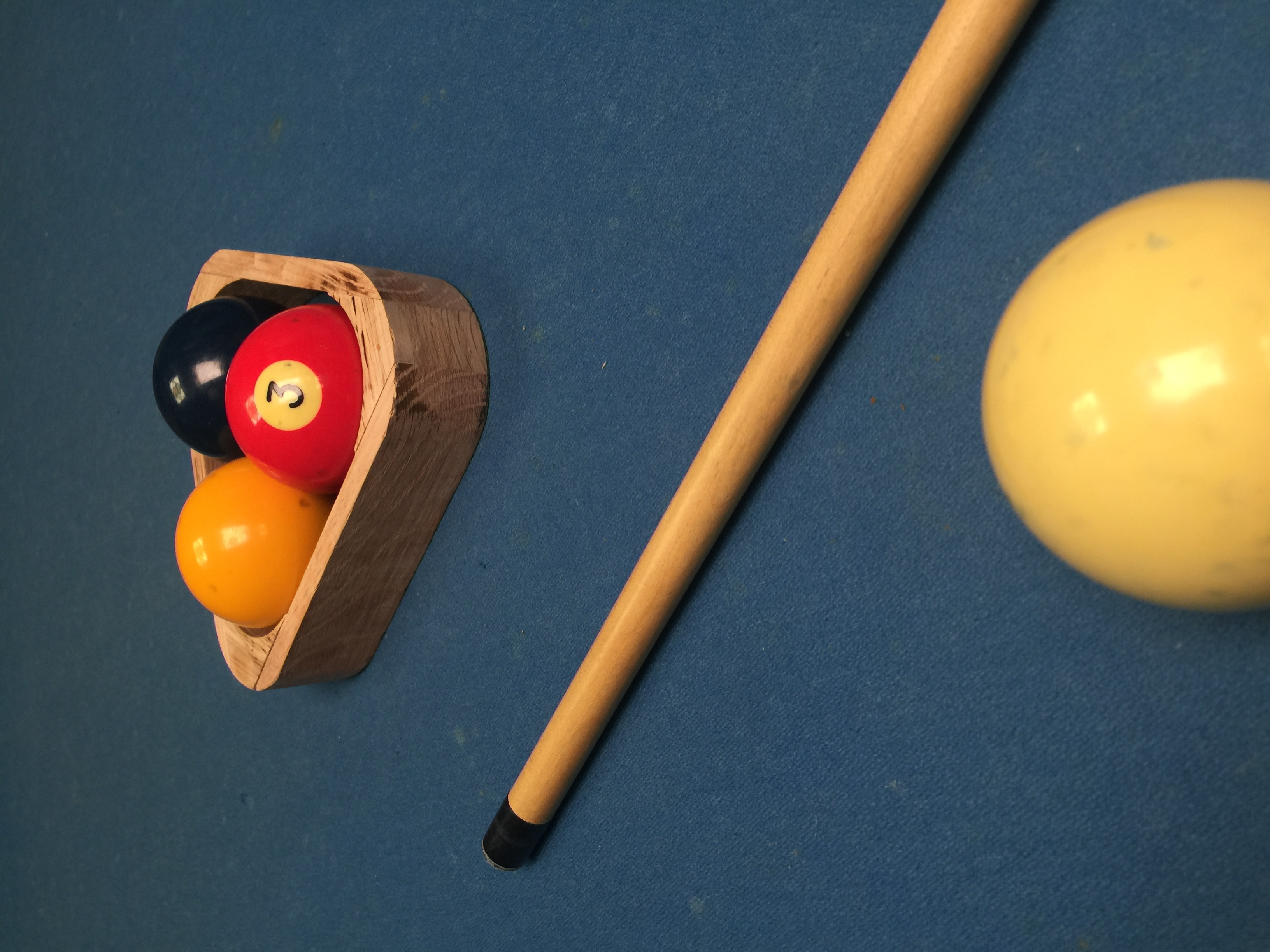 3-ball rack in play — rack, cue, and balls on table